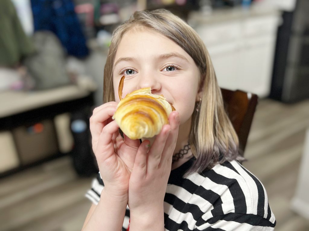 girl eating a croissant 